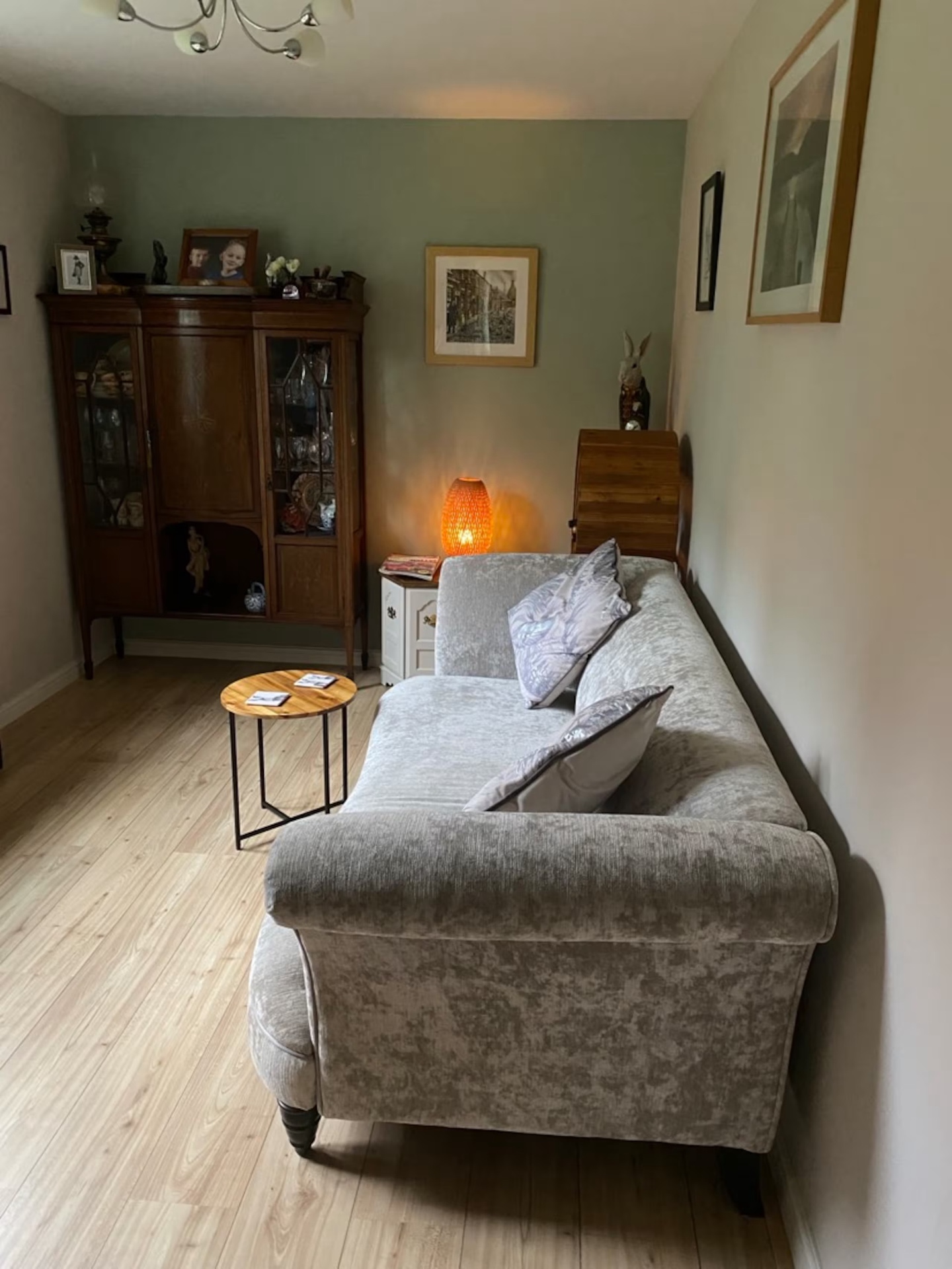 The guest lounge with sofa, antique cabinet and warm lamp