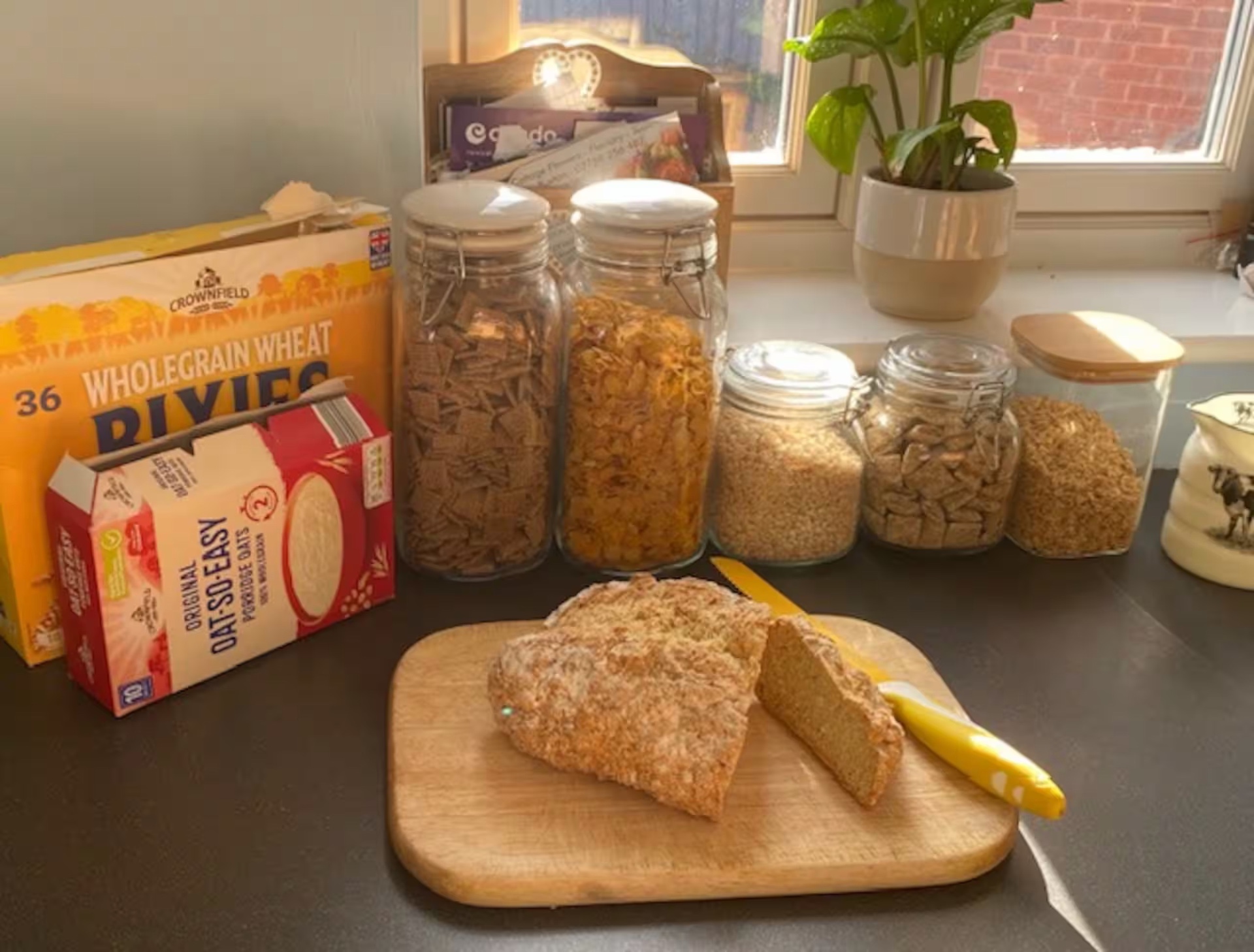 Home-made soda bread on the kitchen counter with cereals in glass jars